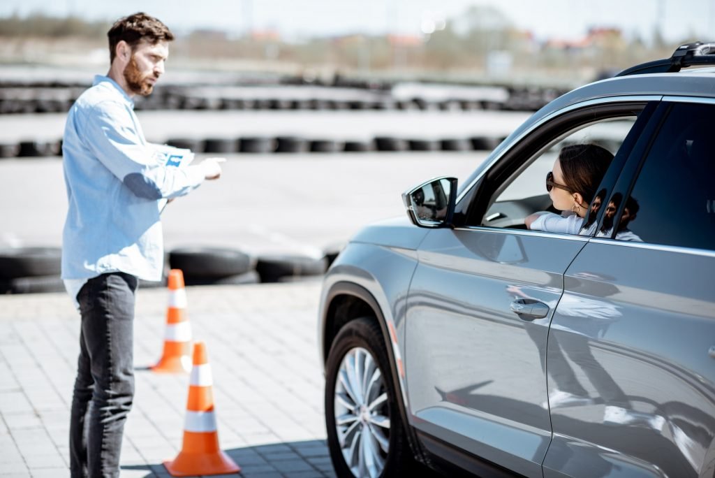 Instructor teaching to drive a car on the training ground