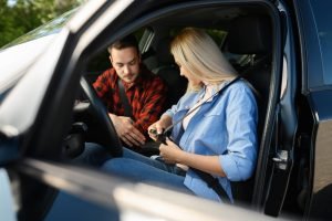 Student fastens seat belt in car, driving school